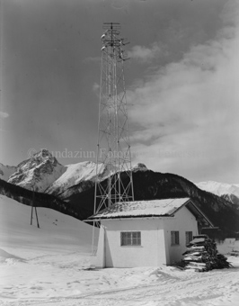 UKW-Sender Tarasp und Häuschen mit Stapel Feuerholz, Schnee