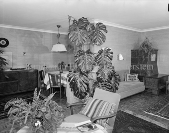 Haus Claudin Vital, Wohnzimmer mit Sesseln und Pflanzen, Kachelofen