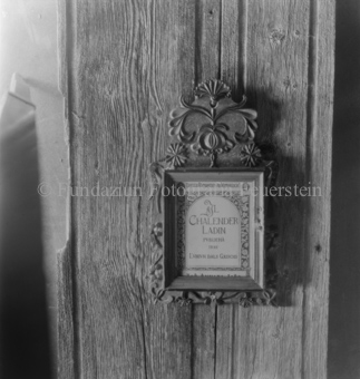 Eingerahmter Kalender «Chalender Ladin» an Holzwand