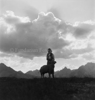 Frau in Tracht mit Schaf, Wolke und Berge
