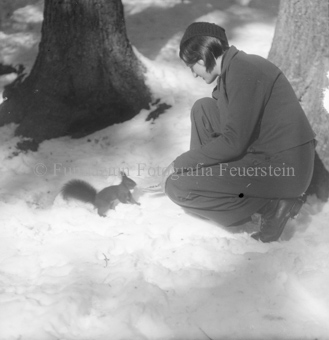 Frau füttert Eichhörnchen im Schnee