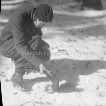 Frau füttert Eichhörnchen im Schnee
