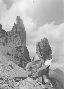 Mann und Frau lesen Karte, hinten Felsformation