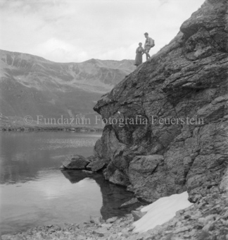 Mann und Frau auf Klippe über Bergsee