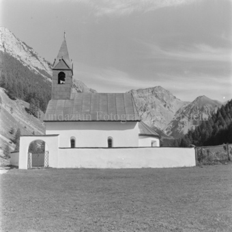 Kirche mit Aussenmauer und Tor, hinten Berge