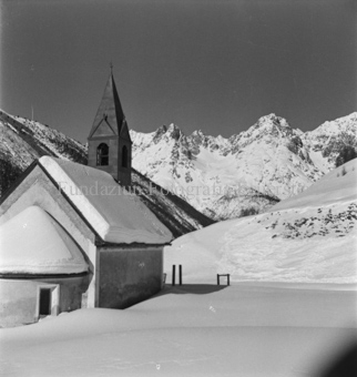 Verschneite Kirche, schneebedeckte Berge