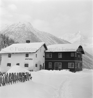 Verschneites Gasthaus, schneebedeckte Berge
