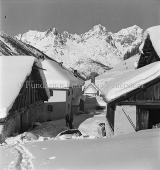 Verschneites Dorf, Blick auf Kirche und Berge