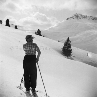 Skitourengängerin, auf verschneitem Hang, blickt zu Bergen 
