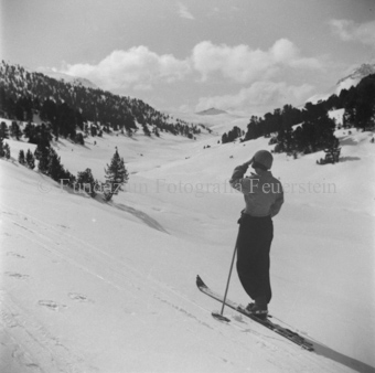 Skitourengängerin, auf Berglandschaft blickend