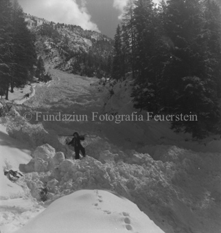 Frau mit Ski auf den Schultern auf Lawinenkegel