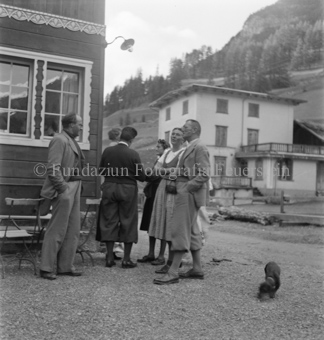 Menschengruppe bei Hausecke bei Pension Feuerstein, Hund