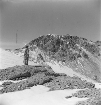 Mann mit Kletterseil auf Fels, Gletscher und Berggipfel