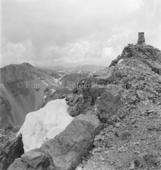 Steinmann auf Bergspitze, unten Gletscher
