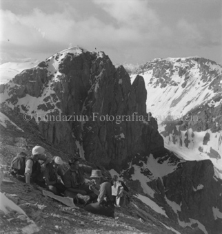 Gruppe Bergsteiger kartenlesend an Hang vor Bergformation