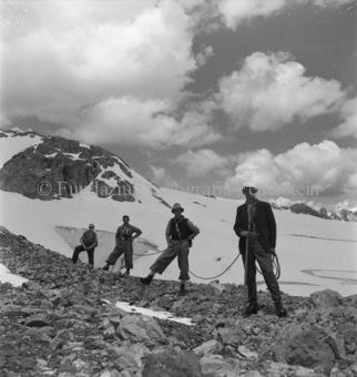 Vier Bergsteiger auf Geröll bei Gletscher