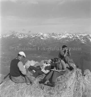 Vier Bergsteiger auf Gipfel, Blick auf Tal und Berge