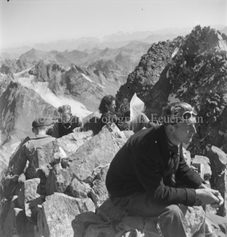 Auf Felsbrocken sitzende Bergsteiger, Berglandschaft
