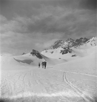 Drei Skitourengänger auf verschneiter Fläche, Gipfel