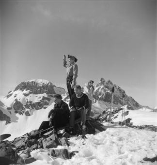 Gruppe Skitourengänger ausruhend, hinten Berggipfel