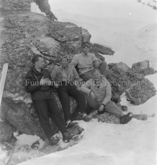 Gruppe Skitourengänger an Felsbrocken gelehnt, Ski abgelegt