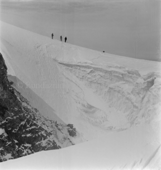 Drei Skitourengänger an oben auf Gletscherwand