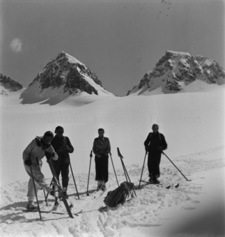 Skitourengängergruppe im Schnee, hinten Berggipfel