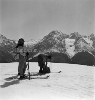 Skitourengängerin und Skitourengänger, Blick auf Berge mit Gletscher, unten Wald