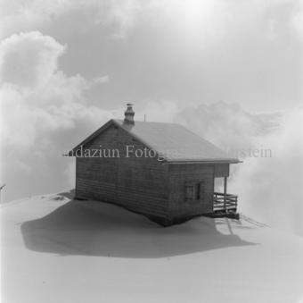 Berghütte in Schnee von hinten, Wolken