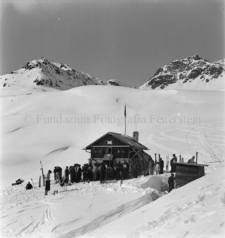 Grosse Gruppe Skitourengänger vor Berghütte «Schlivera Hütte»