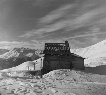 Berghütte von der Seite in verschneiter Berglandschaft