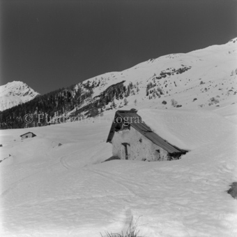 Eingeschneite Skihütte, andere im Hintergrund