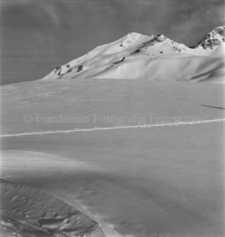 Schneelandschaft mit Skispur, hinten Berggipfel