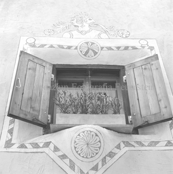 Verziertes Fenster mit Blumen und Holzläden