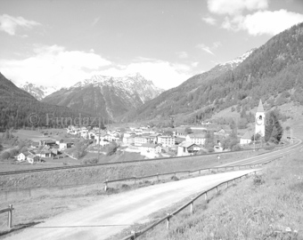 Dorfansicht Lavin mit Bahnlinie und Kirche