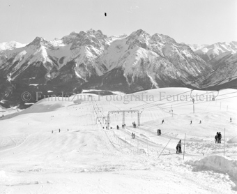 Blick auf Schlepplift Schlivera und Berglandschaft bei Chamanna Naluns, Skifahrer