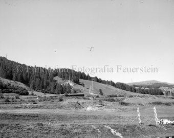 Helikopter mit Bauelement für Seilbahnmast, Blick auf den Hang, Sommer