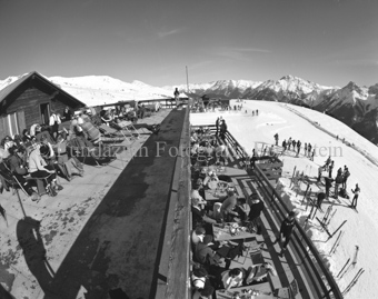 Sonnenterrasse über Restaurant auf Berghütte, viele Personen überall, Skifahrer