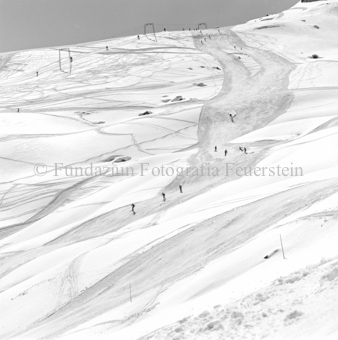 Skifahrer auf der Piste, im Hintergrund Schlepplift Clünas