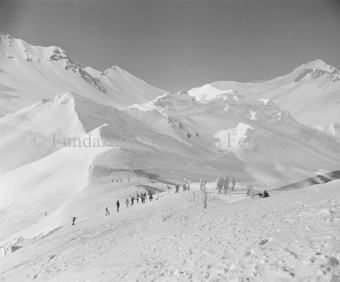 Skifahrer gehen mit Skiern auf den Schultern den Berg hinauf