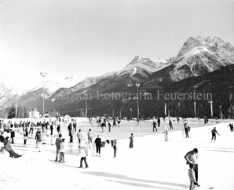 Schlittschuhfahrer in der Sportanlage Trü, Berglandschaft im Hintergrund