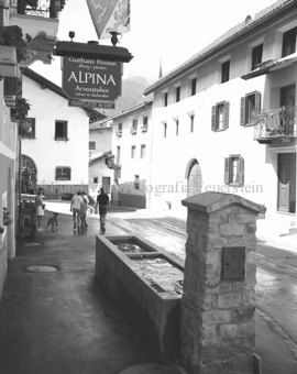 Brunnen neben Hotel «Alpina», Personen auf der Strasse