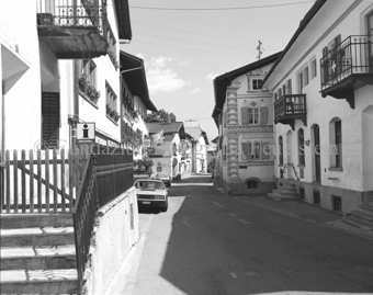 Blick in Strasse, links Hotel «Crusch Alba», rechts Haus mit Sgraffito