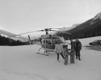 Familie vor Helikopter im Schneefeld
