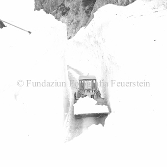 Schneeräumung auf der Strasse nach Lawine mit Flachbagger