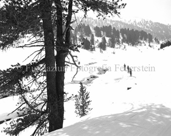Skitourengänger neben Bach in Schneelandschaft