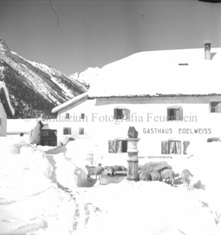 Verschneiter Dorfplatz, Schafe beim Brunnen vor Gasthaus «Edelweiss»