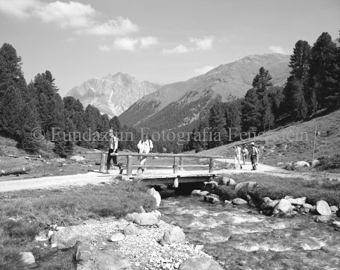 Wanderer auf Brücke und Weg über Bach