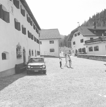 Blick auf Dorfplatz S-charl, Kinder auf der Strass neben Auto