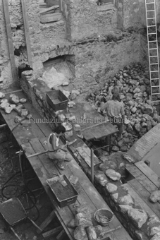 Restauration der Schmelzra, Arbeiter mit Mörtel und Steinen auf Holzgerüst